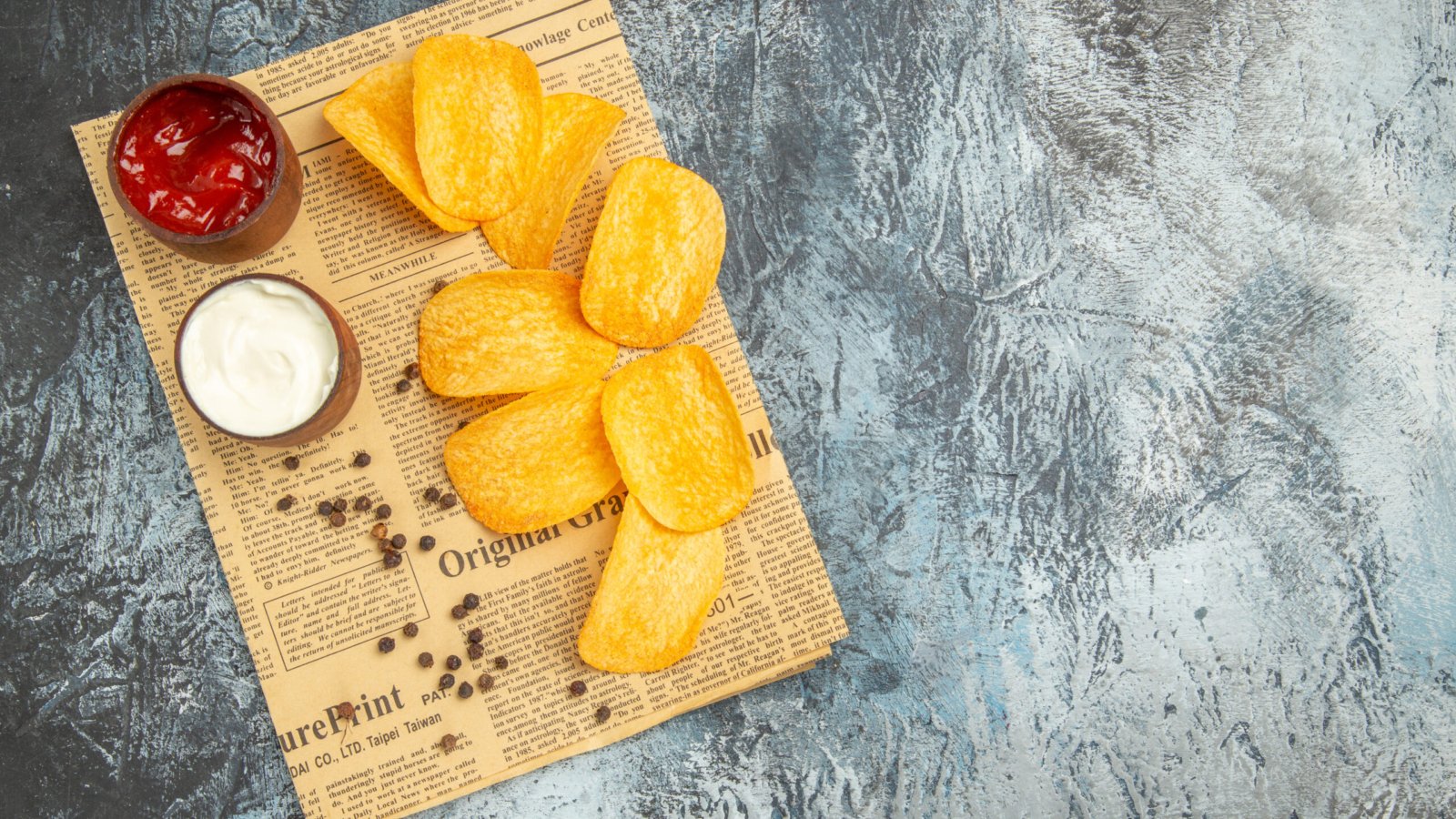 horizontal-view-delicious-homemade-chips-pepper-bowl-mayonnaise-ketchup-newspaper-gray-table